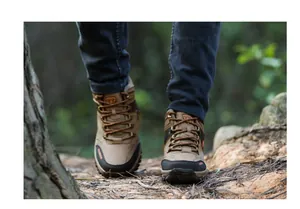 Durable high-top hiking boots for men and women shown walking on a forest trail
