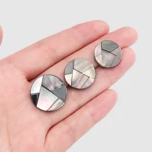 Detailed view of handmade black mother-of-pearl buttons showing natural iridescent luster