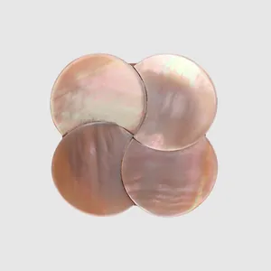 Detailopname van een handgemaakte roze schelpknoop met een uniek iriserend inlegontwerp