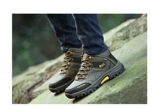 Close-up of olive green high-top hiking boots for men on mossy outdoor rock surface