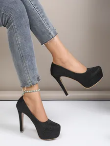 Side view of black glitter 16cm platform stiletto heels on model with jeans