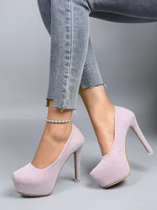Close-up side view of pink glitter platform high heels with 16cm stiletto heel on model