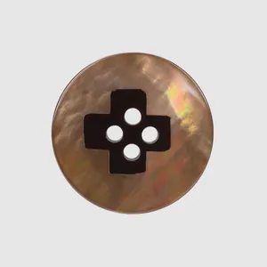 Close-up of a brown mother-of-pearl shell button with a cross-shaped 4-hole design