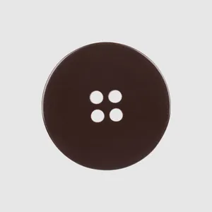 Detailed macro view of a dark brown four-hole shell button for high-end mink coats.