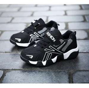 Detailed side view of black children's mesh running sneakers on stone pavement