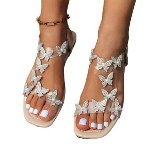 Eleganti sandali piatti bianchi con ornamenti a farfalla in strass luccicanti per l'estate