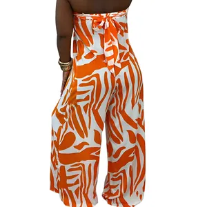 Back view of orange and white abstract print sleeveless wide-leg jumpsuit with tie detail.
