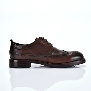 Gedetailleerd zijaanzicht van handgemaakte bruine leren brogue herenschoenen.