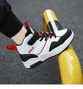 Primo piano di eleganti sneakers alte da basket per bambini in bianco, nero e rosso