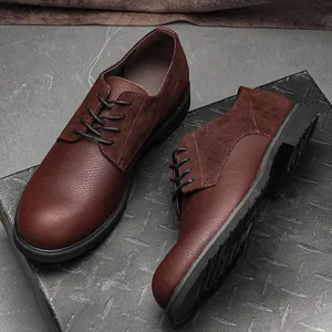 Detailed view of men's genuine brown leather shoes with suede and grain texture