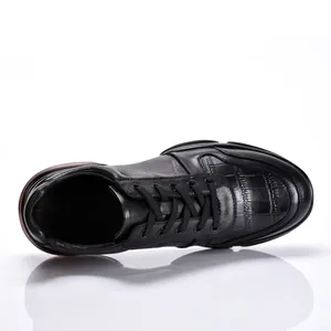 Gedetailleerd bovenaanzicht van hoogwaardige zwarte herensneakers van leer met krokodillenpatroon