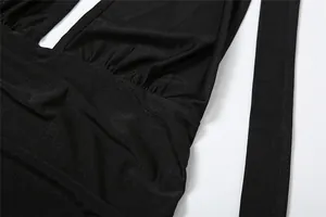 Primer plano de vestido halter negro sexy con escote en V profundo y frunces.