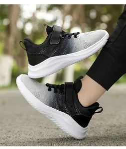 Dettaglio delle scarpe da corsa leggere per bambini con sfumatura grigio-nera sulla strada