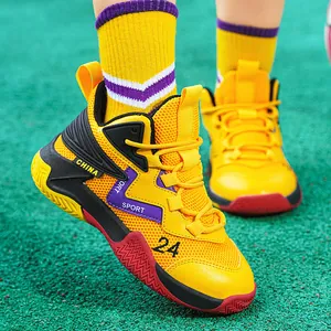 High-angle view of vibrant yellow and purple children's mesh basketball shoes on green turf