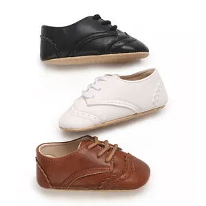 Chaussures de marche pour bébé en cuir PU noir, blanc et marron avec lacets et semelle souple.