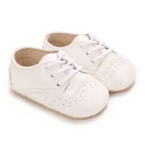 Vue détaillée de chaussures pour bébés à semelle souple blanche avec motifs brogues.