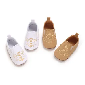 Detailansicht von Baby-Lauflernschuhen mit goldener Stern- und Schneeflockenbestickung