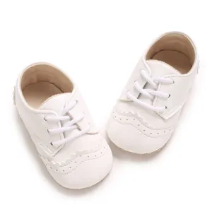 Gros plan détaillé de chaussures brogues pour bébé à semelle souple blanche avec perforations