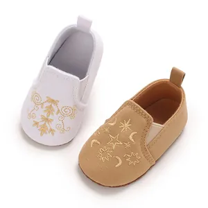 Detailansicht von Baby-Leinwandschuhen mit eleganten goldenen Stickerei-Verzierungen