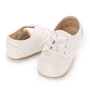 Gros plan détaillé de chaussures de marche blanches pour bébé avec surpiqûres brogue