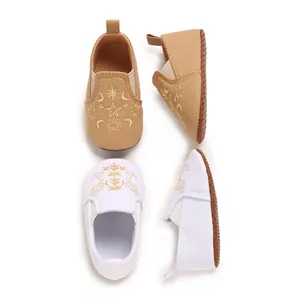 Detail von Baby-Lauflernschuhen mit weicher Sohle und Stickmustern in Weiß und Khaki