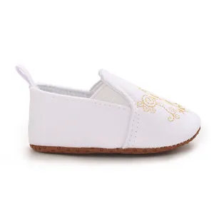 Seitenansicht der weißen Baby-Lauflernschuhe mit goldener Stickerei und weicher Sohle.