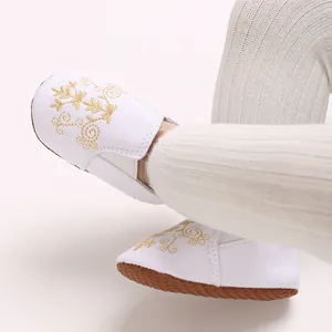 Detailansicht von weißem Baby-Lauflernschuh mit weicher Sohle und Goldbestickung