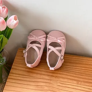 Close-up of pink baby girl princess shoes with soft soles and decorative bow straps