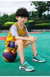 Asian boy sitting on a basketball wearing teal breathable mesh basketball shoes