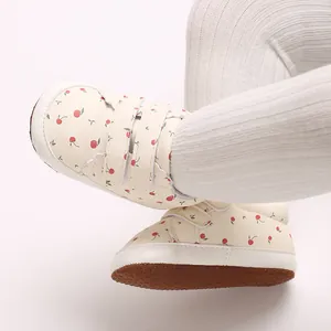 Detailaufnahme von Baby-Lauflernschuhen mit Kirschprint und rutschfester weicher Sohle