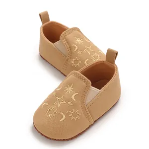 Detailansicht der khakifarbenen Baby-Lauflernschuhe mit Stern- und Mondstickerei