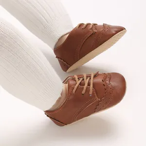 Gros plan sur des chaussures Oxford marron pour bébé à semelle souple et lacets