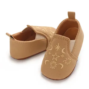 Detailansicht khakifarbener Babyschuhe mit Sternen- und Mondstickerei für Lauflerner