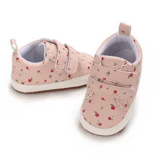 Detailansicht der rosa Baby-Lauflernschuhe mit rotem Kirschprint und Klettverschluss.