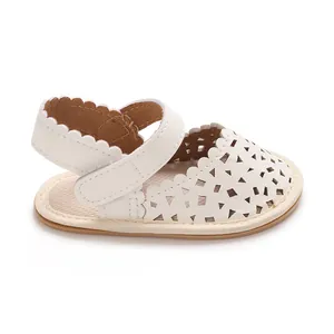 Vue latérale détaillée de sandales de marche blanches pour bébés avec motifs ajourés et semelle.