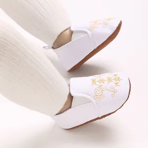 Detailansicht der weißen Baby-Lauflernschuhe mit eleganter goldener Blumenstickerei