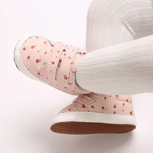 Detaillierte Nahaufnahme von rosa Babyschuhen mit Kirschprint und weicher Anti-Rutsch-Sohle