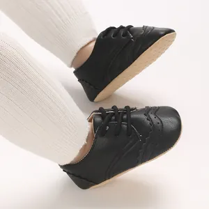 Détail de chaussures de marche noires style richelieu pour bébé garçon avec semelles souples