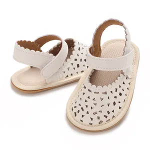 Détail de sandales blanches pour bébés filles avec motifs découpés et semelles souples