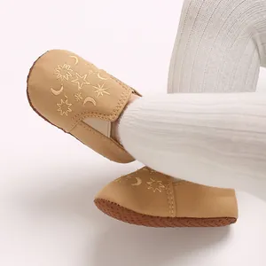 Nahaufnahme von khakifarbenen Baby-Lauflernschuhen mit Sternenstickerei und weicher Sohle