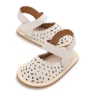 Gros plan de sandales de marche blanches pour bébés filles avec motif ajouré