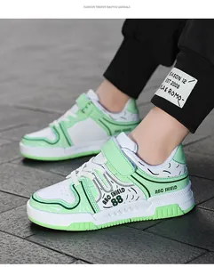 Primer plano de zapatillas blancas y verdes para niños con velcro en los pies.