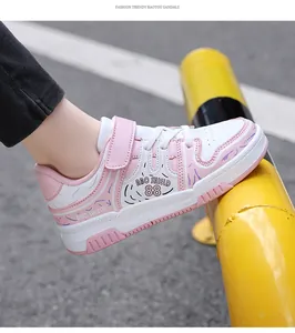 Vista lateral detallada de zapatillas de skate para niños en rosa y blanco con tira de velcro