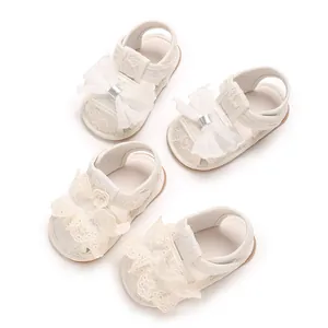 Detailansicht weißer Babysandalen für Mädchen mit zarten Spitzen und Mesh-Schleifen