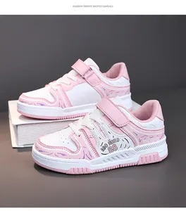 Vista detallada de las zapatillas rosas y blancas para niños con velcro y logo ABC SHIELD.