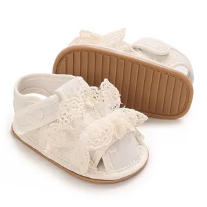 Detail von Baby-Sandalen für Mädchen mit eleganten Spitzenrüschen und rutschfester Gummisohle.