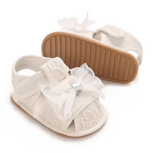 Detailaufnahme weißer Baby-Sandalen aus Spitze mit rutschfester Gummisohle