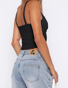 Close-up side view showing black ribbed crop camisole and light blue denim jeans
