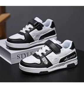 Dettaglio laterale di sneakers per bambini in pelle bianca e nera con cinturino in velcro