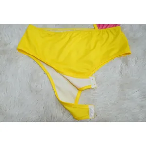 Macro detail view of the snap button closure on a bright yellow bodysuit for women